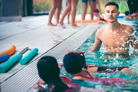 maître-nageur avec des enfants dans une piscine