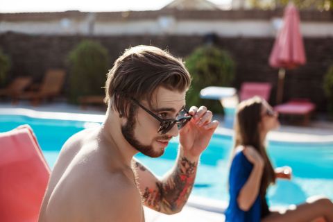 homme tatouage sur le bras à la piscine
