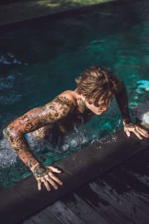 homme tatouage sur le bras à la piscine